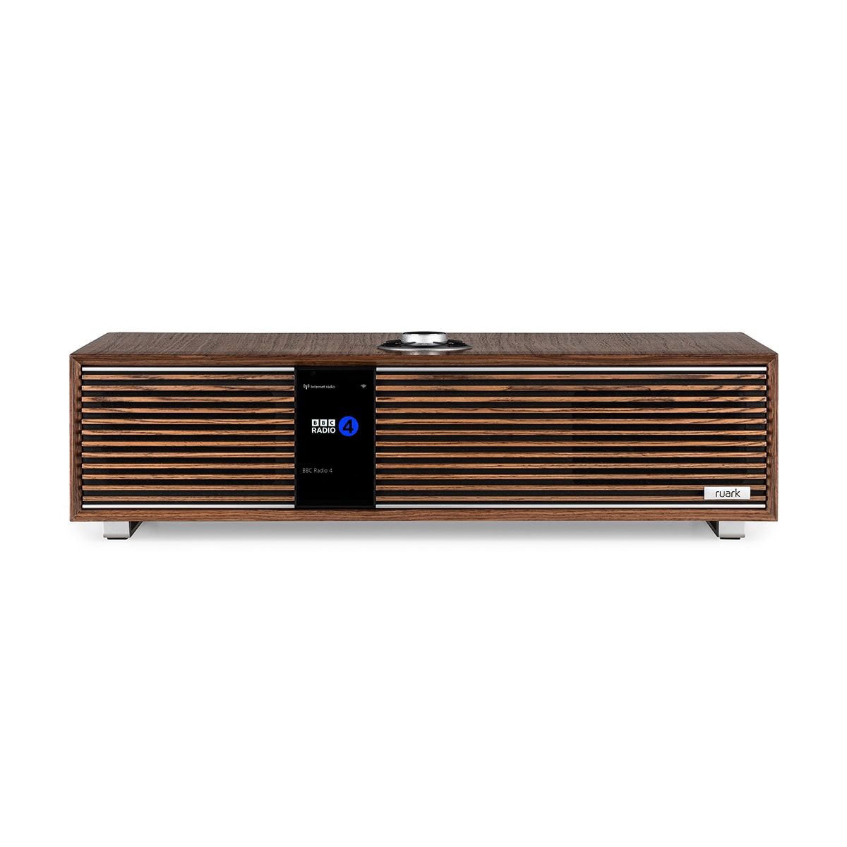 Čelní pohled na Ruark Audio R410 s ručně vyráběnou lamelovou mřížkou, chromovými detaily a barevným displejem zobrazujícím internetové rádio